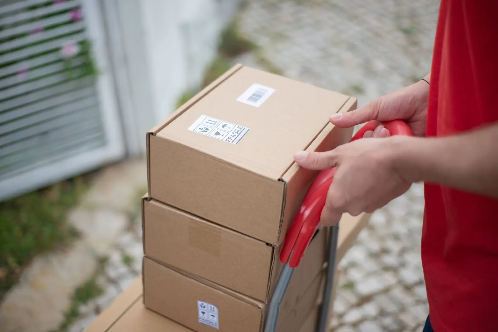 Moving a stack of labeled boxes on a hand truck