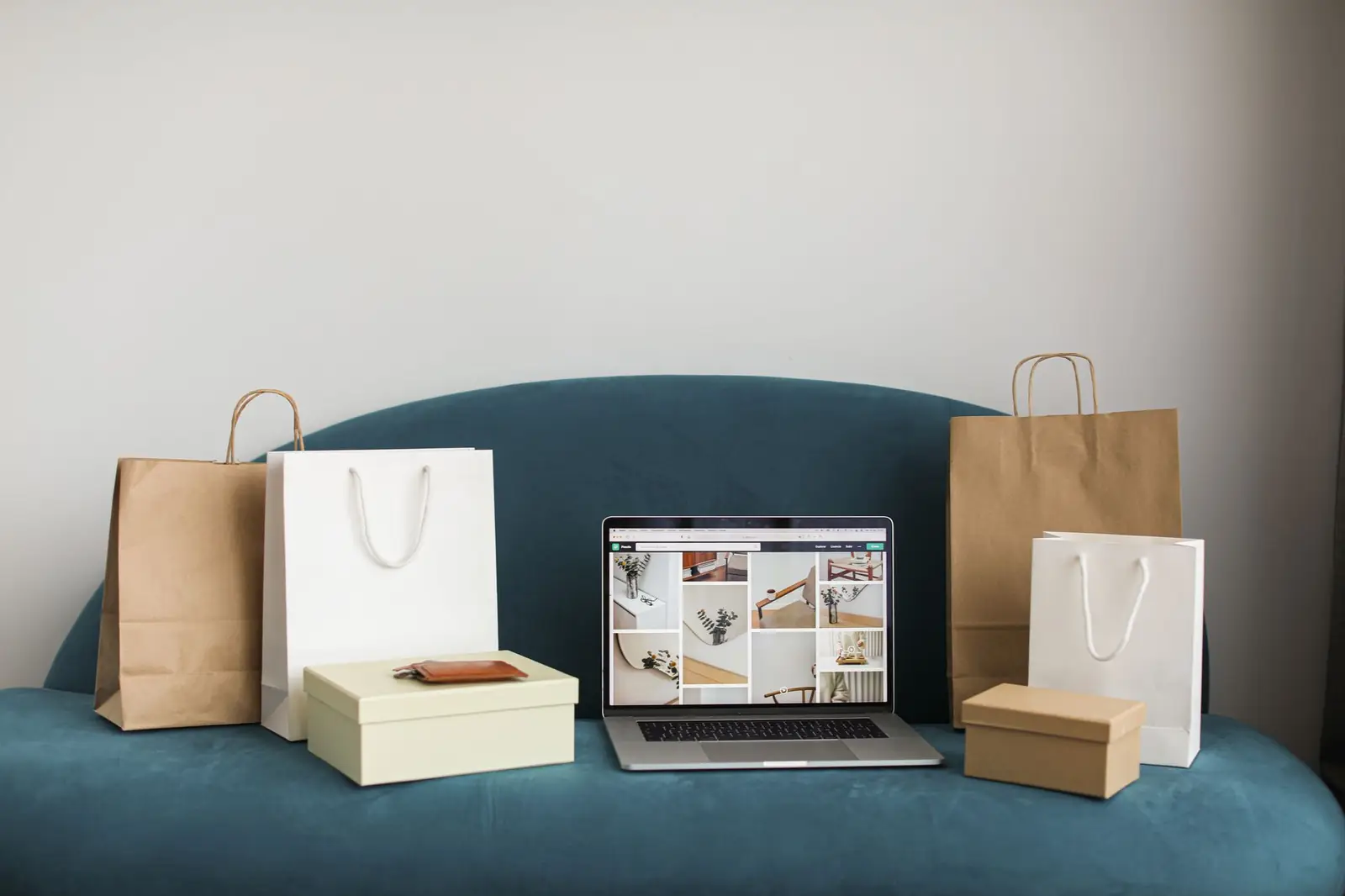 Laptop showing an online store next to shopping bags and product boxes