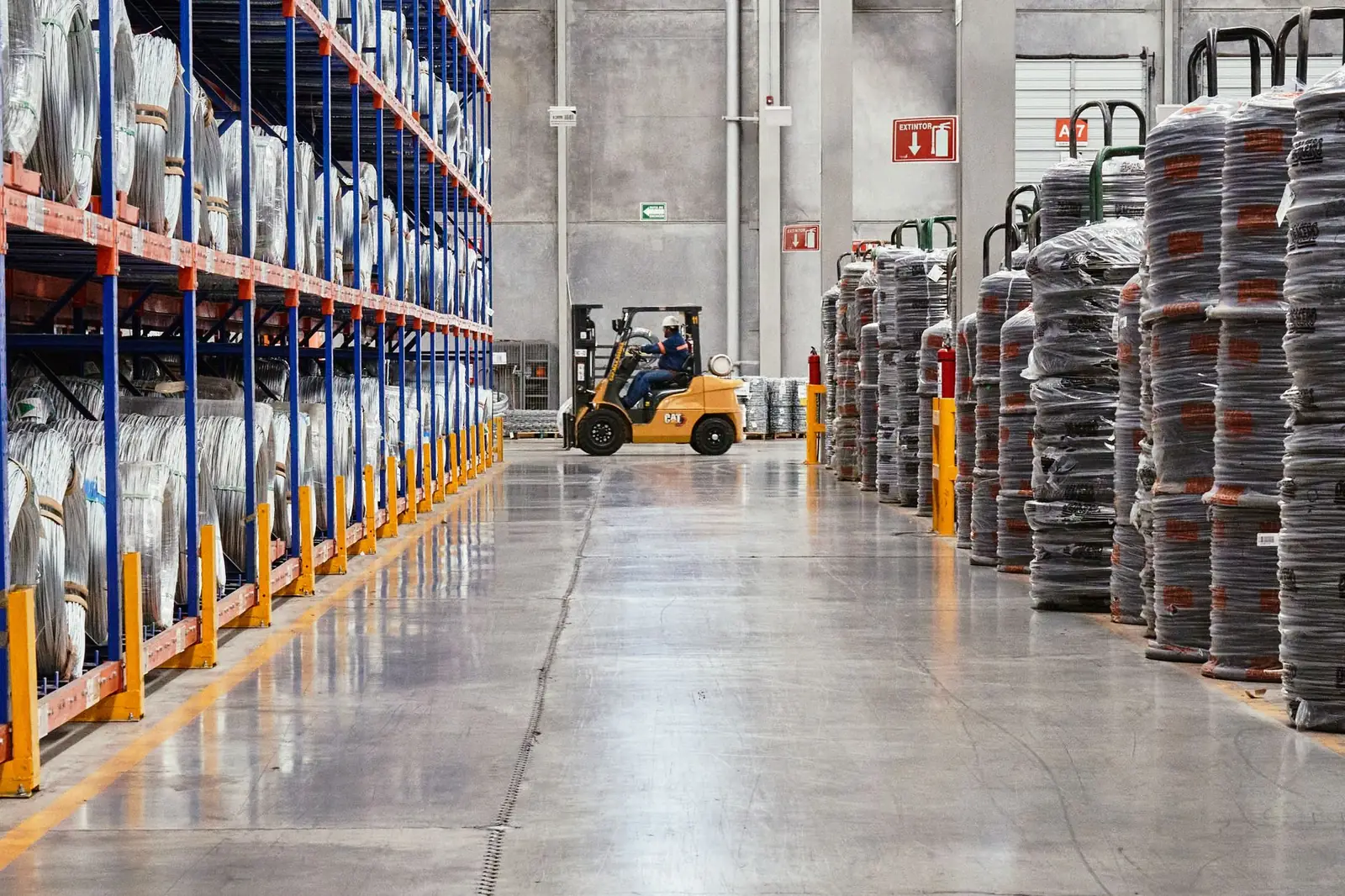 Forklift working in a long aisle of warehouse racking